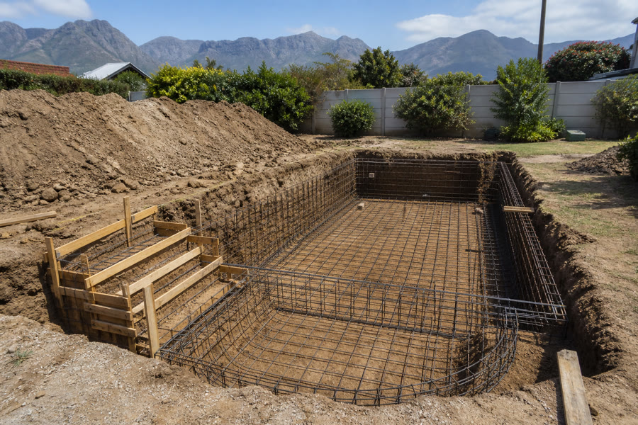 Excavated pool hole with a steel reinforcing cage and timber step formwork in a Somerset West garden